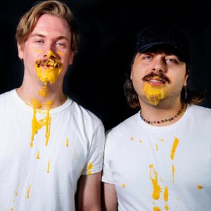 two men with yellow paint on their faces and shirts