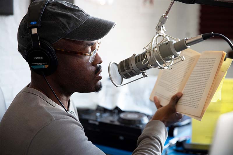 lost_shelfless_2-flip Man reading into microphone