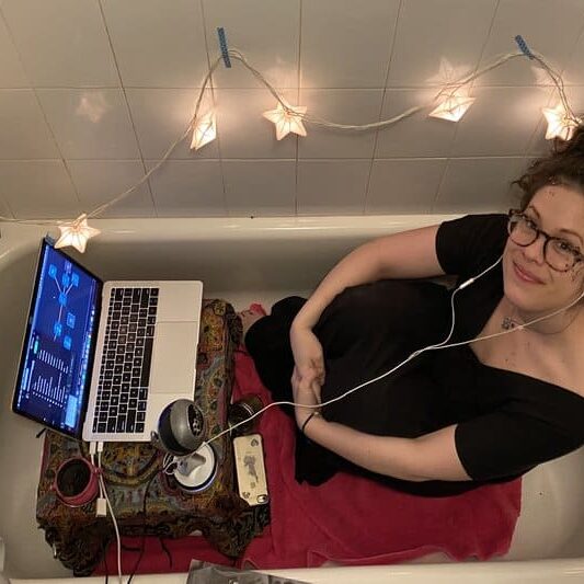 Ali Darling in a bathtub with a laptop
